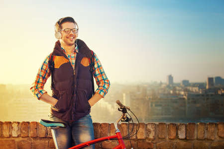 Young handsome man is making break while riding bike.の写真素材