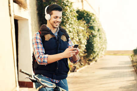 Young handsome man is making break while riding bike.の写真素材