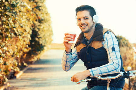 Young handsome man is making break while riding bike.の写真素材