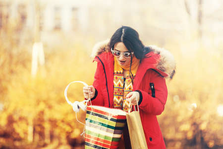 Cold autumn day. Young woman in shopping.の写真素材