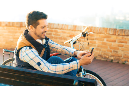 Young handsome man is making break while riding bike.の写真素材