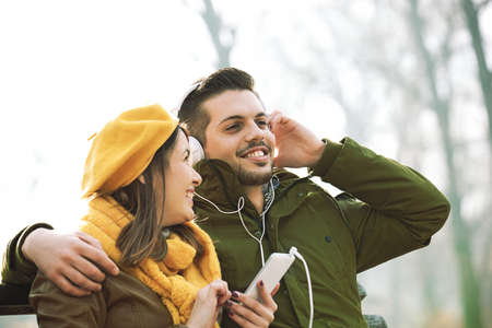 Young and attractive couple enjoying fall in the park.の写真素材