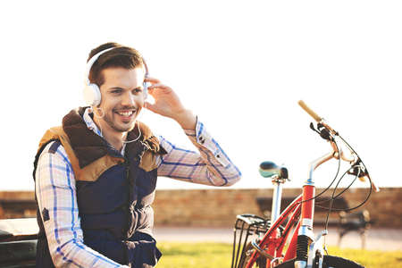 Young handsome man is making break while riding bike.の写真素材