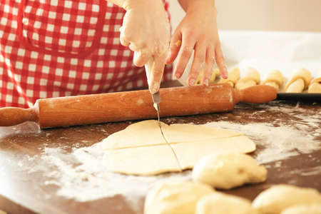Woman in the kitchen preparing croissants to bake.の写真素材