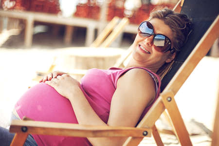 Young pregnant woman is enjoying beach early in the morning.の写真素材
