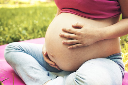 Young pregnant woman is enjoying spring.