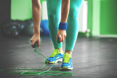 Young fit woman is taking jumping rope.