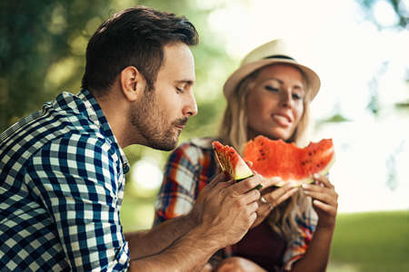Friends enjoying nature and eating watermelon.Spring time.の写真素材