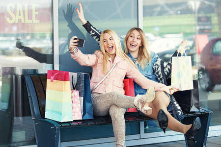 Beautiful women enjoying shopping. Girls having fun.の写真素材