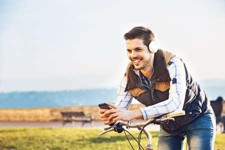 Young handsome man is making break while riding bike.の写真素材