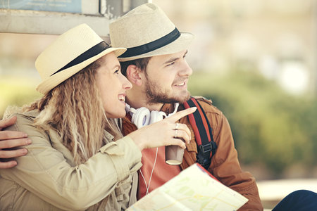 Couple tourist waiting for the bus and looking at city map.の写真素材