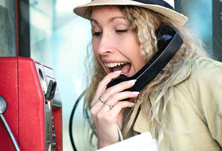 Young tourist woman using telephone booth.の写真素材