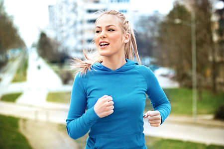 Young blonde woman is jogging early in the morning.の写真素材