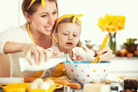 Mum and daughter baking cakes.
