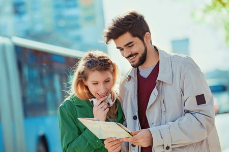 Young tourists in the city looking at map.