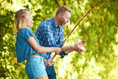 Young friends enjoying nature in the morning and fishing.の写真素材