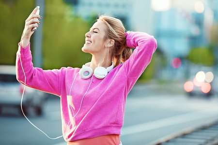 Attractive and sporty girl exercising on the bridge. Living healthy lifestyle. Relaxing with...