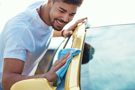 Young handsome man is washing his car.の写真素材