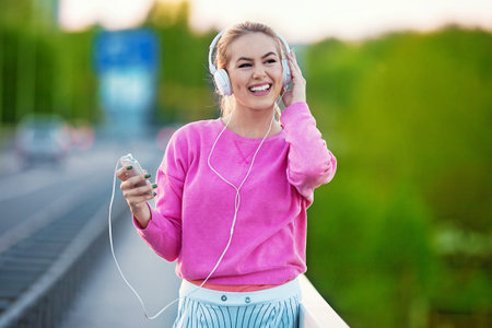 Attractive and sporty girl exercising on the bridge. Living healthy lifestyle. Relaxing with...