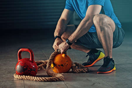 Young athlete man is training with kettlebell in garage.の写真素材