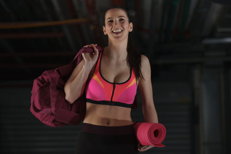 Young strong woman is ready for training in garage.