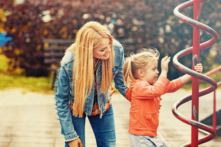 Happy family of two. Blonde mum and daughter in the park.の写真素材