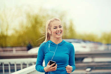 Young blonde woman is jogging early in the morning.の写真素材