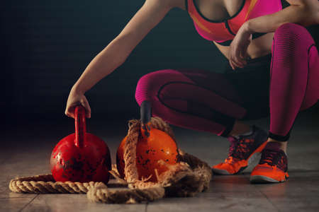 Young athlete woman is exercising  with kettlebell in garage.の写真素材