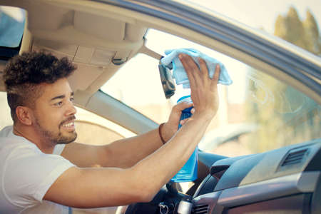 Young handsome man is washing car outdoor.の写真素材