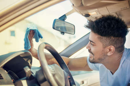 Young handsome man is washing car outdoor.の写真素材