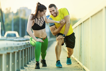 Sportive young couple exercising on the bridge early in the morning. Living healthy lifestyle.