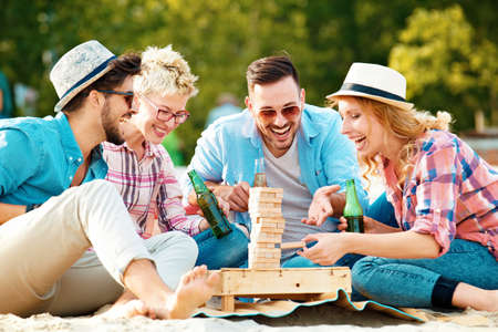 A group of friends having great time together on the beach and palying game.の写真素材