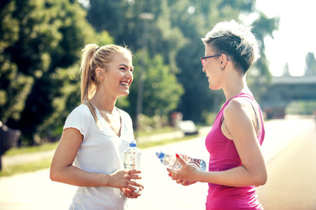 Two young women having break after jogging.