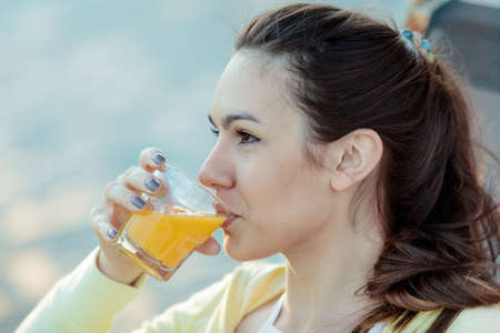 Sportive and attractive young woman drinking orange juice after exercising.の写真素材