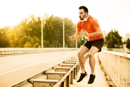 Young handsome man is exercising on the bridge.の写真素材