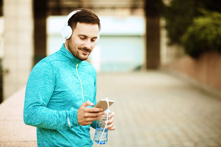 Young handsome man is listening music on the phone.の写真素材
