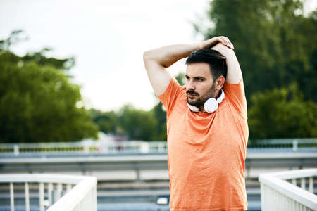 Young handsome man is exercising on the bridge.の写真素材