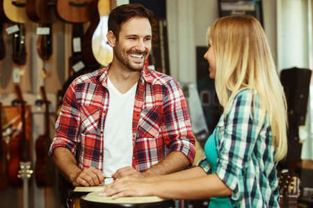 Musicians playing congas in musical instrument store.の写真素材