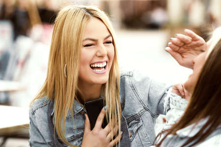 Happy young women having fun in coffee shop.の写真素材