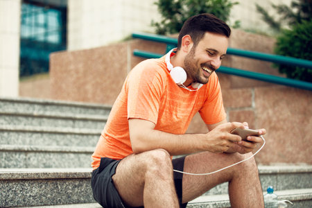 Young handsome man is listening music on the phone.の写真素材