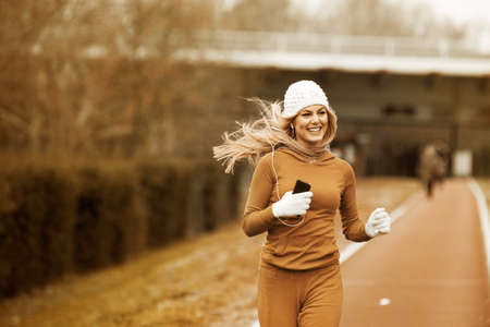 Young blonde woman is enjoying fall and jogging.の写真素材