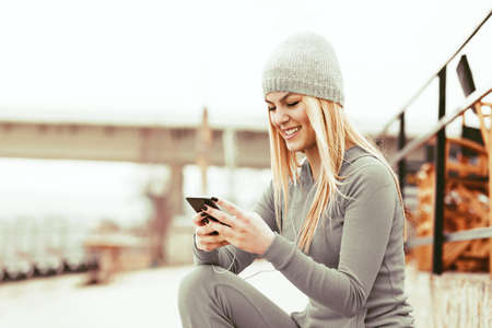 Young blonde woman is listening music and enjoying beach.の写真素材