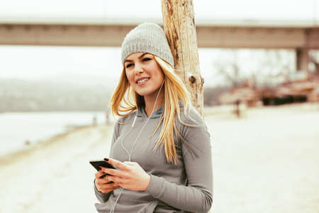 Young blonde woman is listening music and enjoying beach.の写真素材