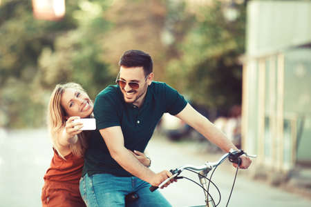 Young couple enjoying bike in the city.の写真素材