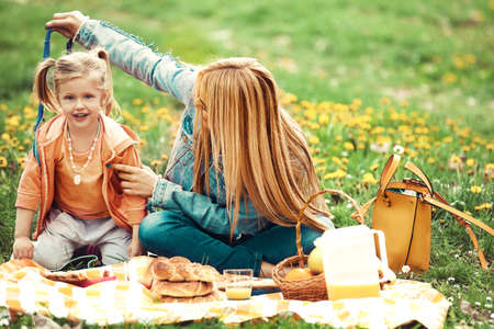 Young mother is enjoying picnic with her daughter.の写真素材