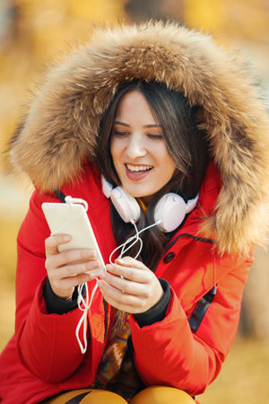Beautiful young woman enjoying autumn in the park.の写真素材