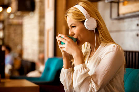 Blonde business woman is enjoying in restaurant and fleelance job.の写真素材