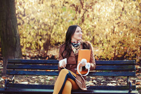 Beautiful young woman enjoying autumn in the park.の写真素材