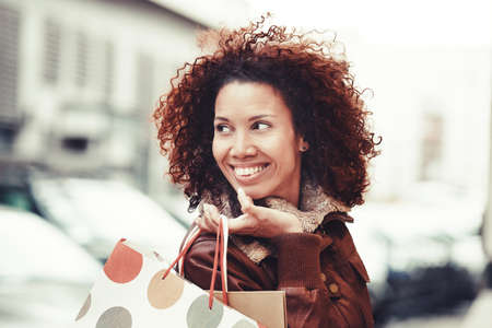 Beautiful woman enjoying shopping in autumn day.の写真素材