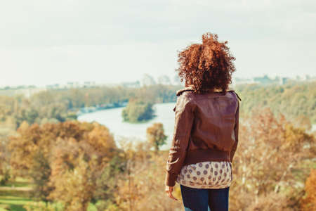 Beautiful woman enjoying autumn day in the park.の写真素材